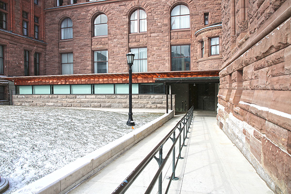 exterior view of a ramp leading down to entrance of visitors' screening centre 
