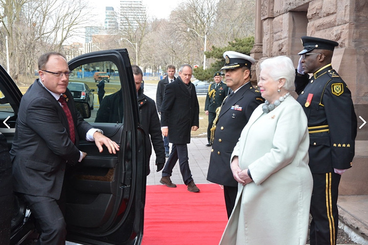 Lieutenant Governor of Ontario standing outside main Legislative Building with two LPS officers in ceremonial uniform