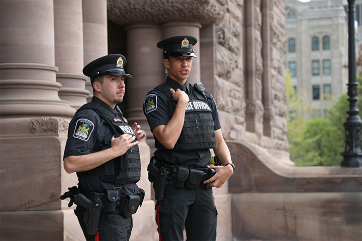 two peace officers standing in front of Legislative Building