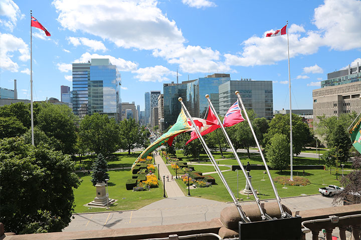 Les drapeaux de l’Ontario et du Canada devant l’édifice de l'Assemblée législative 